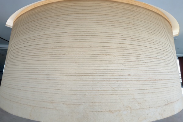 A worker applying flexible stone to a wall using a notched trowel.