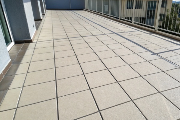 A person using a grout float to apply grout to a tiled wall
